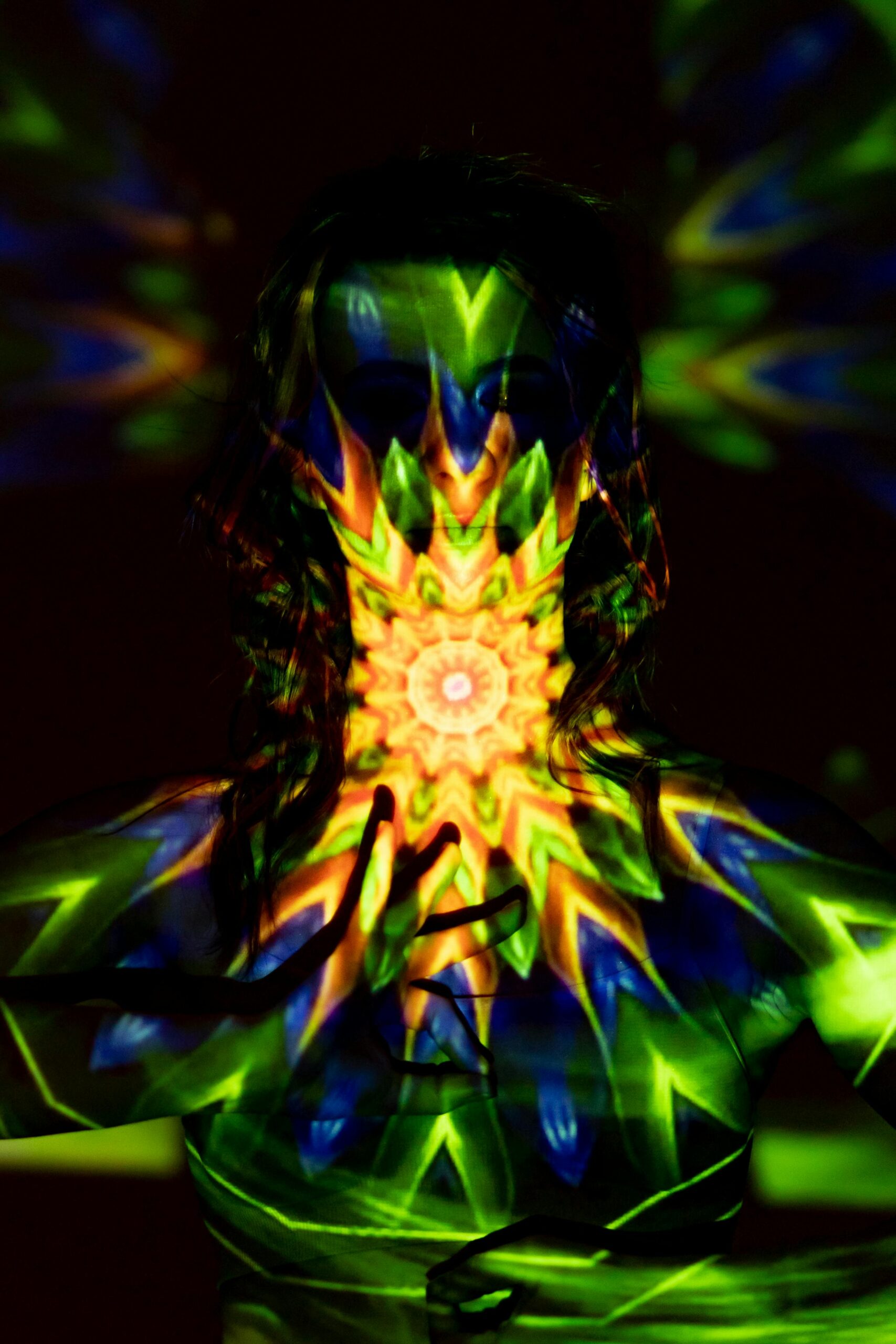 Colorful light patterns projected on a woman's silhouette, evoking spiritual energy and balance.